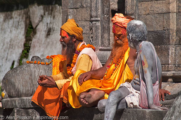 Three Hindu Sadhus are having a serious discussion at a Kathmandu monument.