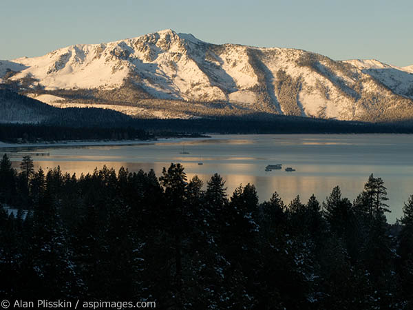 Late afternoon Winter light illuminates the mountains surrounding Lake Tahoe.