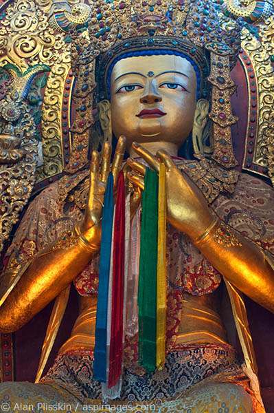 Candlelight lights up this Buddha in a temple at Bodnath.