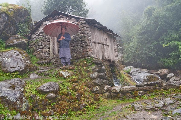 Standing next to one of the many mini-hydroelectric plants along the trail, this local lady is waiting for the rain to subside.